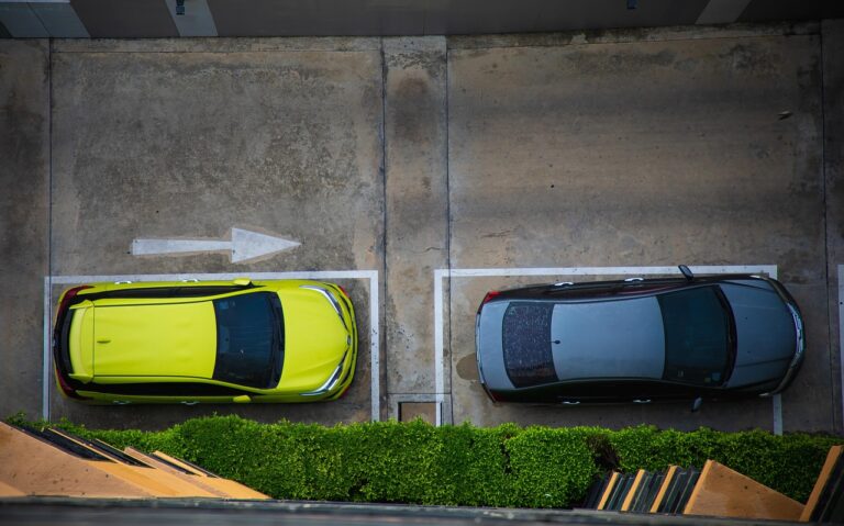 A car parked in a busy parking lot near office buildings, representing finding work parking.